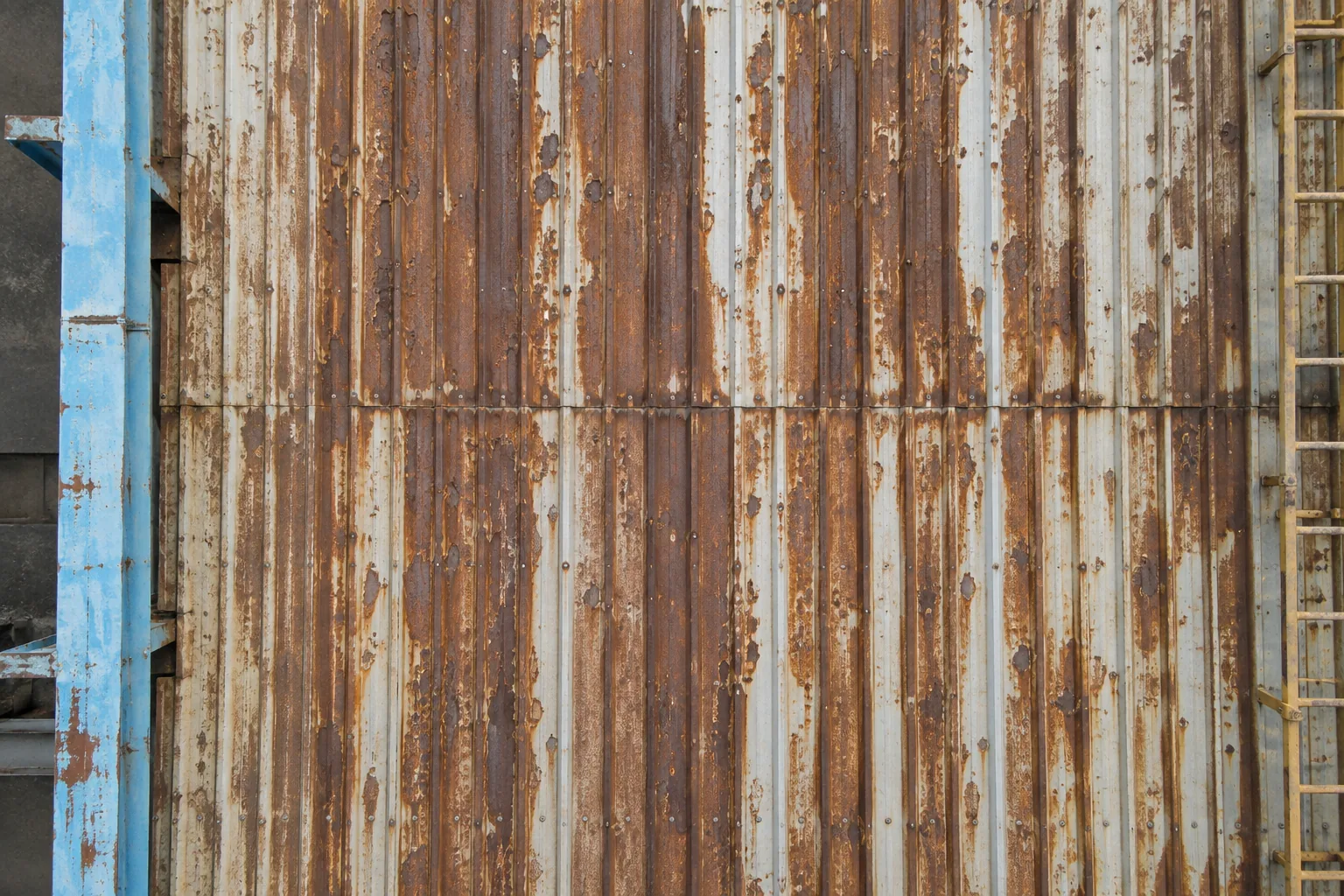 Close view of corroded corrugated cladding with streaks of rust